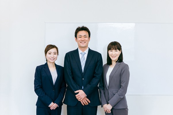 起立するスーツ姿の男女