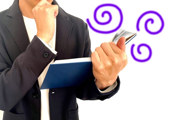 本を片手に考える男性