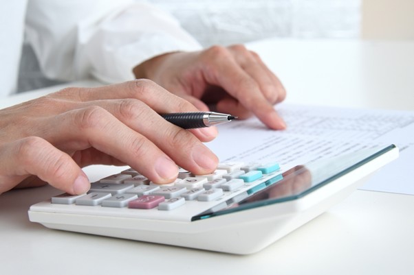 電卓をたたくビジネスマン