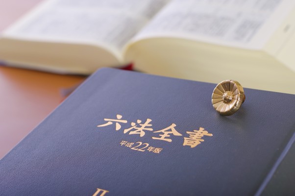 六法全書と弁護士バッジ