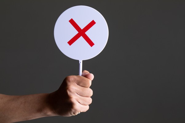 ✕マークを掲げる手