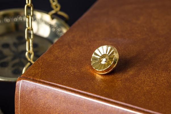 本の上に置かれた弁護士バッジ