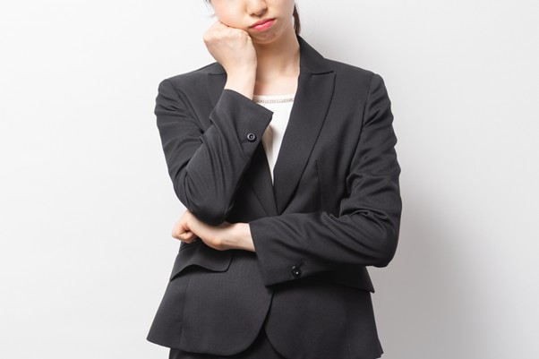 腕を組み考える女性