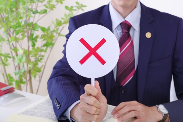 ×マークを持つ男性弁護士