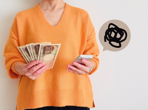 紙幣と携帯を持つ女性