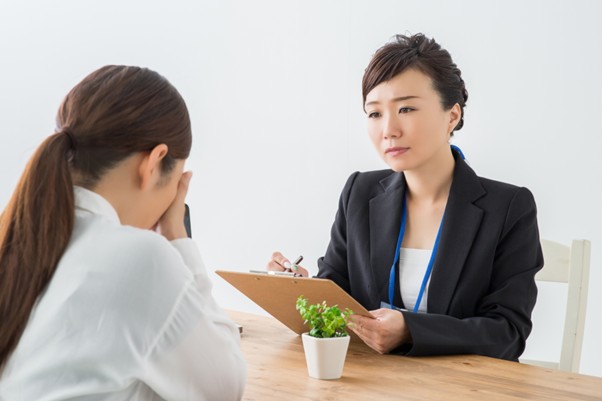 女性の話を聞くスーツ姿の女性