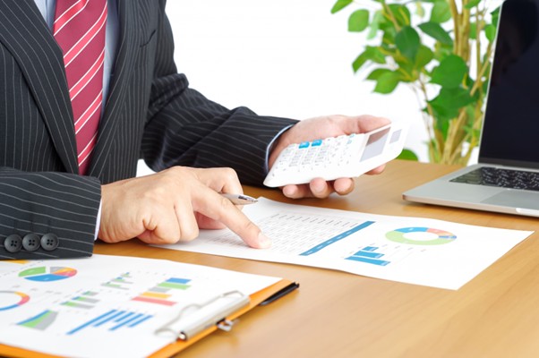 グラフをみて電卓を持つビジネスマン