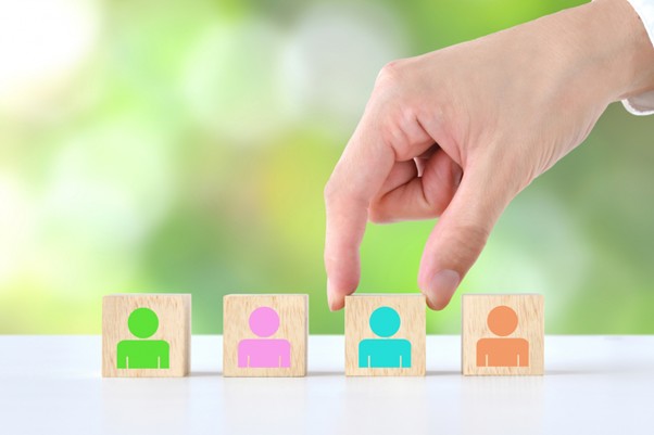 人が描かれた積み木を持つ手