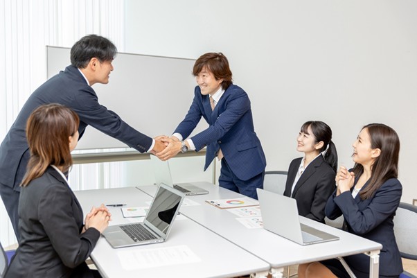 会議中握手するビジネスマン