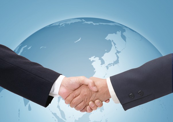 地球を背景に握手するビジネスマン