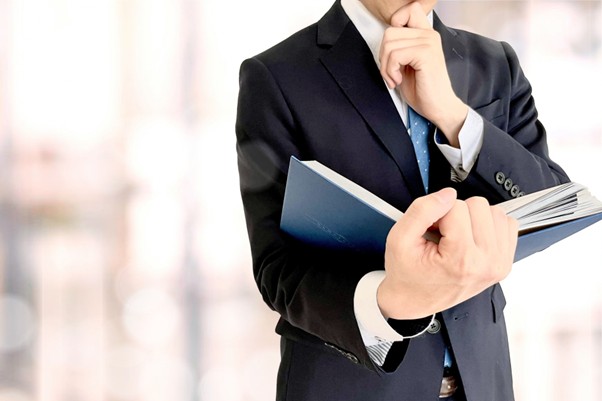本を読みながら考えるビジネスマン