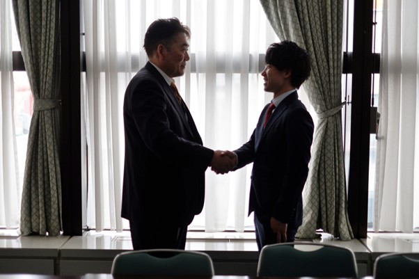 窓際で握手するビジネスマン