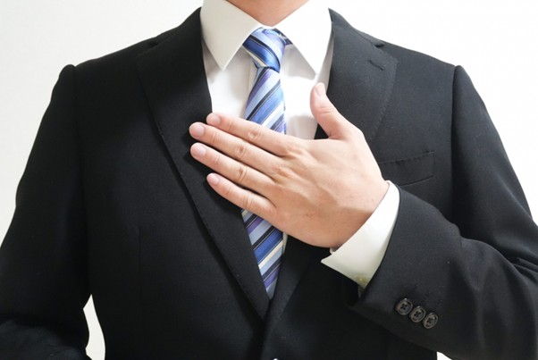 胸に手を当てるビジネスマン