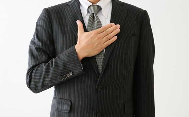 胸に手を当てるビジネスマン