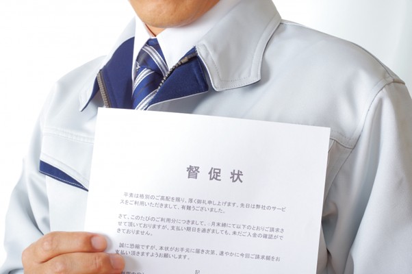 督促状を持つ作業服の男性