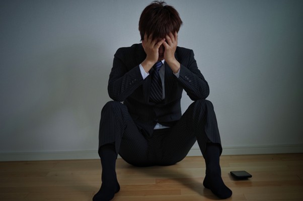頭を抱えて座るビジネスマン