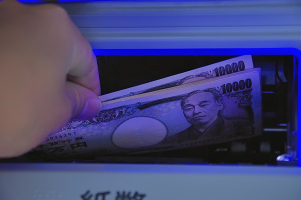 ATMから一万円札を取り出す人