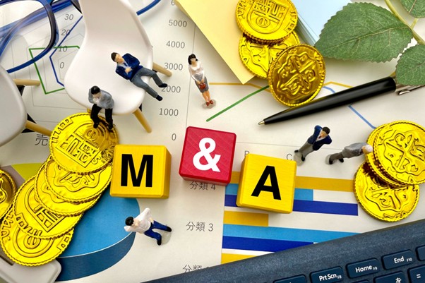 M＆Aの文字と人形、ちらばる硬貨