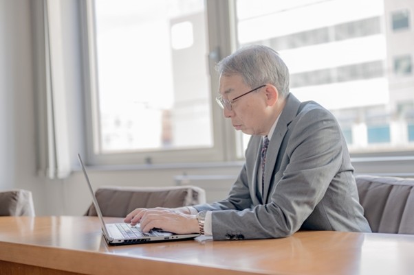PCを扱う高齢のビジネスマン