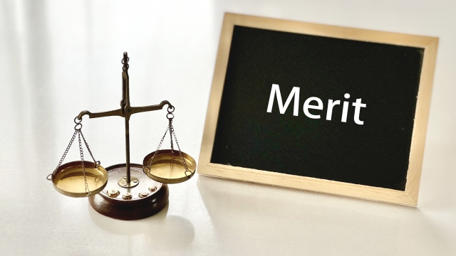 天秤とミニ黒板にMeritの文字