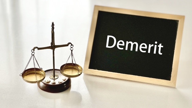 天秤とミニ黒板にDemeritの文字