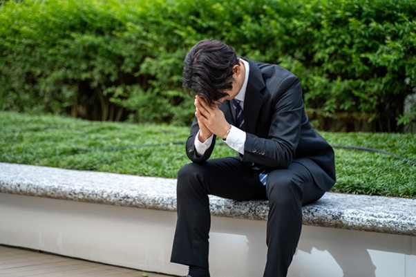 ベンチで悩むビジネスマン