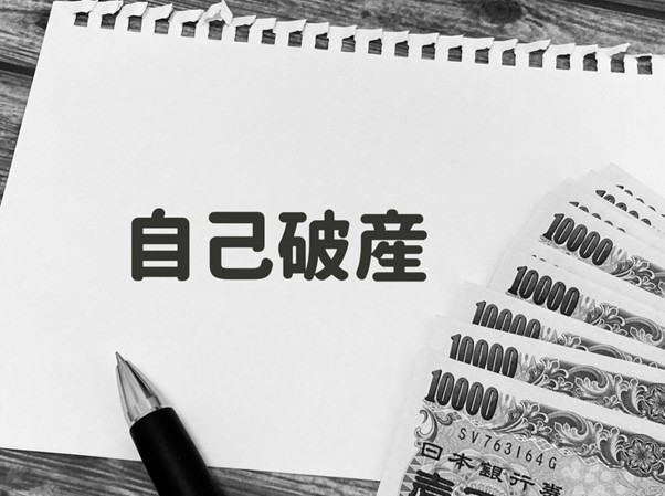 一万円札と自己破産の文字が書かれた紙