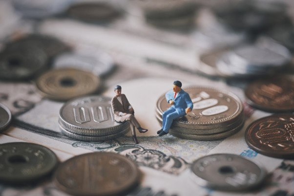 小銭の上に座るビジネスマン