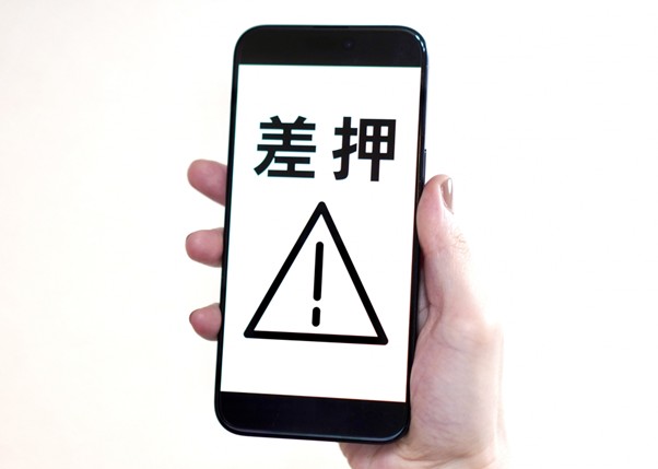 差押と表示されたスマホ