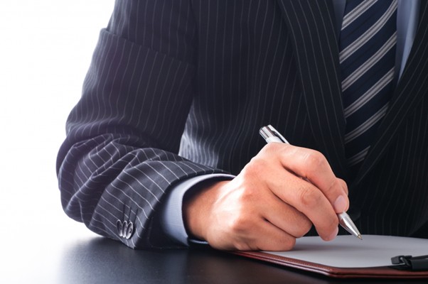 書類に書こうとするビジネスマン