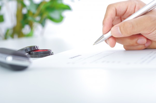 書類を書く人と印鑑