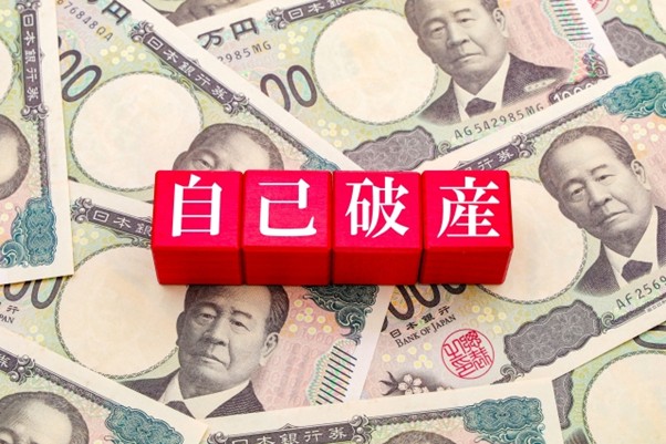 お札の上に自己破産の文字ブロック